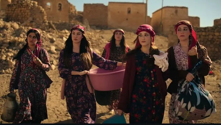 Yöresel kıyafetli kadın oyuncular taş köyde yürürken