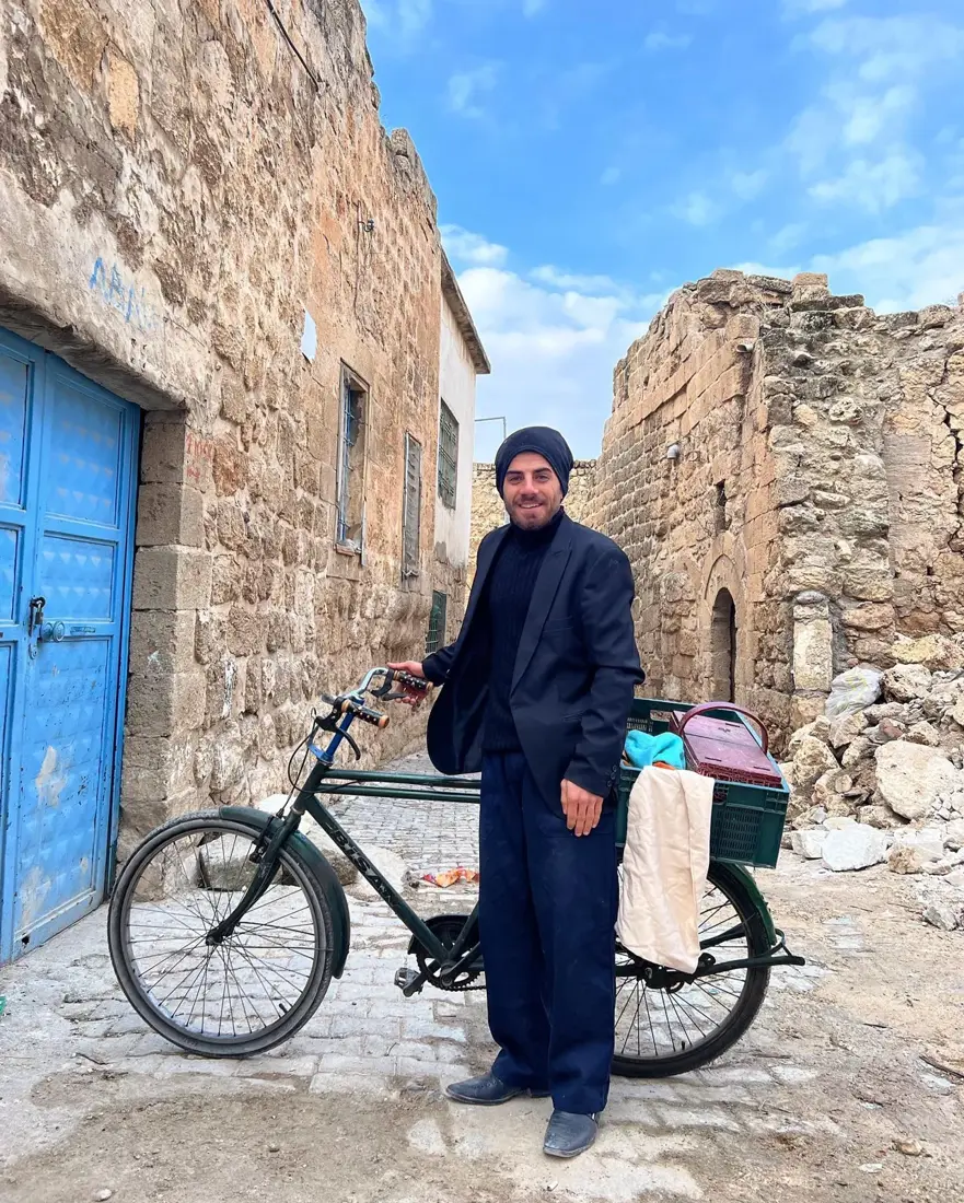 Mardin'de taş sokakta bisikletli oyuncu, set arası